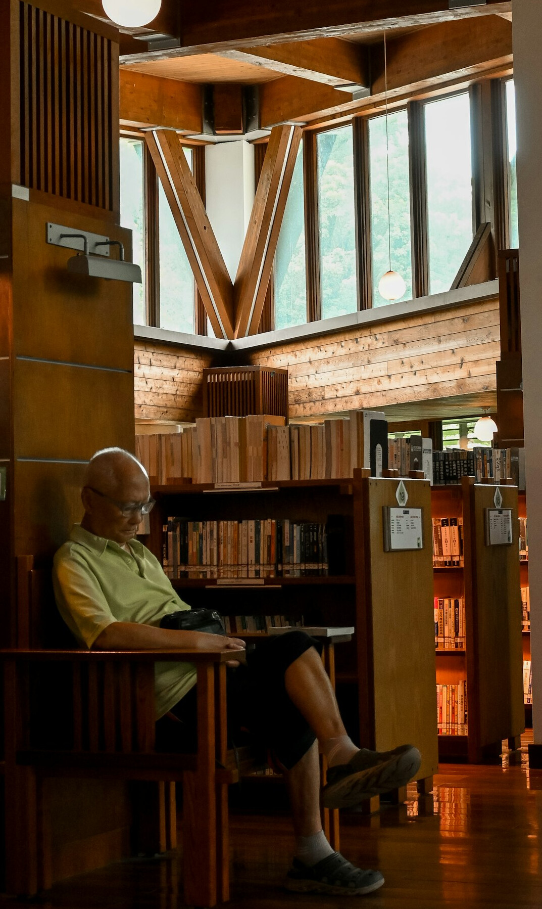 man reading book in library